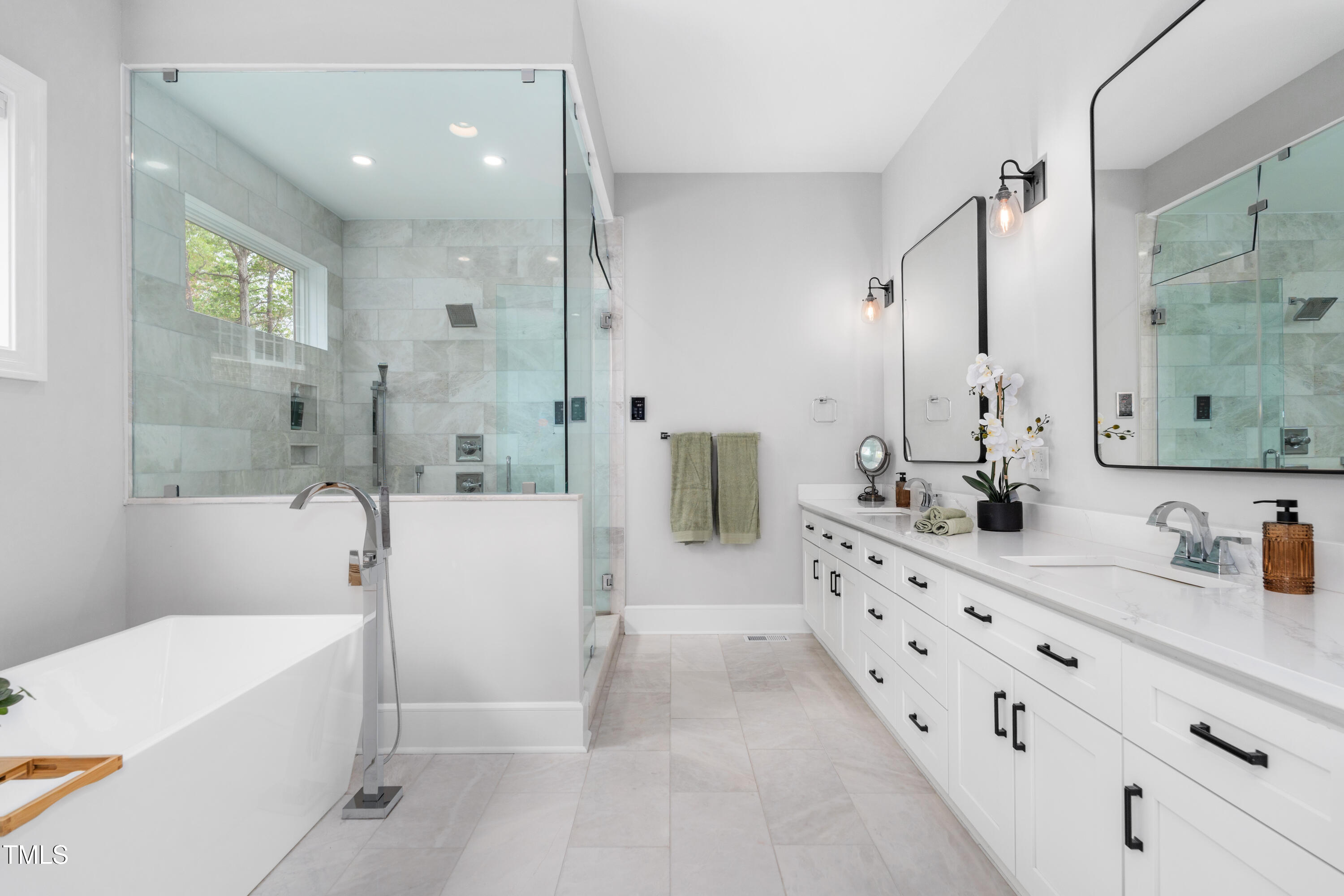 1213 Rocky Point Lane Durham, NC 27712 - Photo 24 of 76 a bathroom with a double vanity sink a mirror a bathtub and shower
