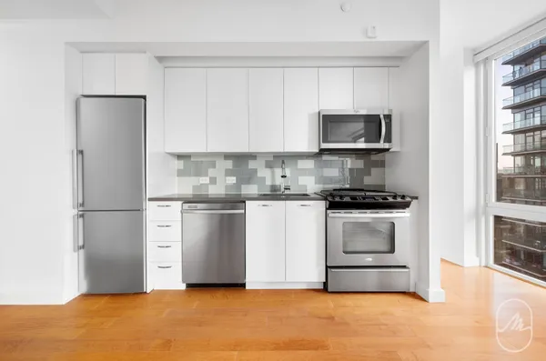 a kitchen with stainless steel appliances white cabinets and a refrigerator