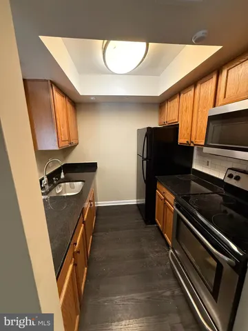 a kitchen with stainless steel appliances granite countertop a refrigerator and a stove