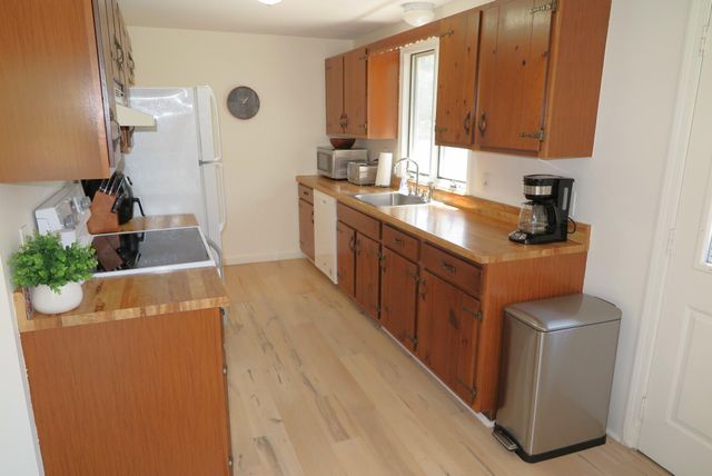 a kitchen with sink a refrigerator and wooden cabinets