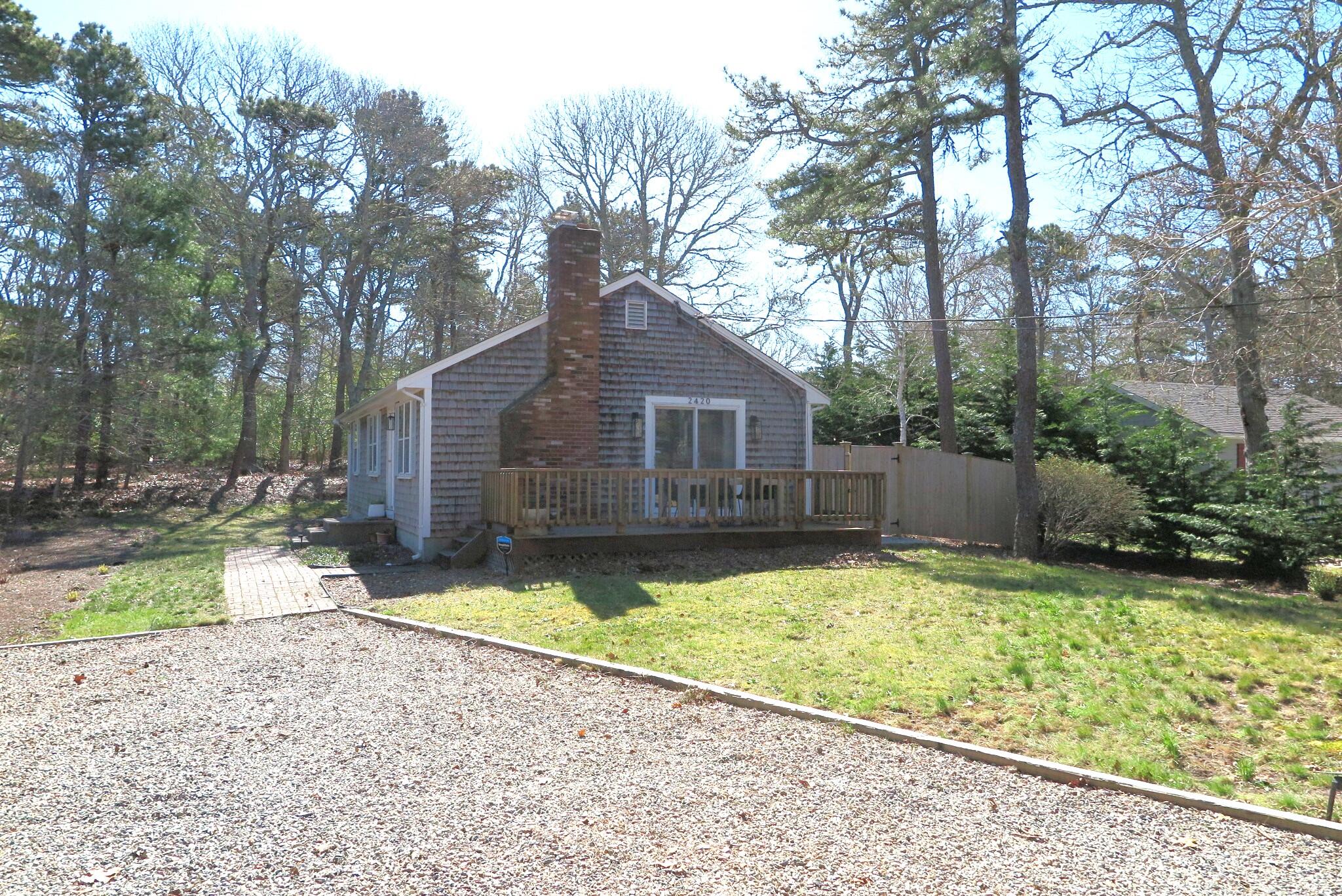 2420 Herring Brook Road Eastham, MA 02642 - Photo 23 of 37 a view of a backyard with a large tree and a small yard
