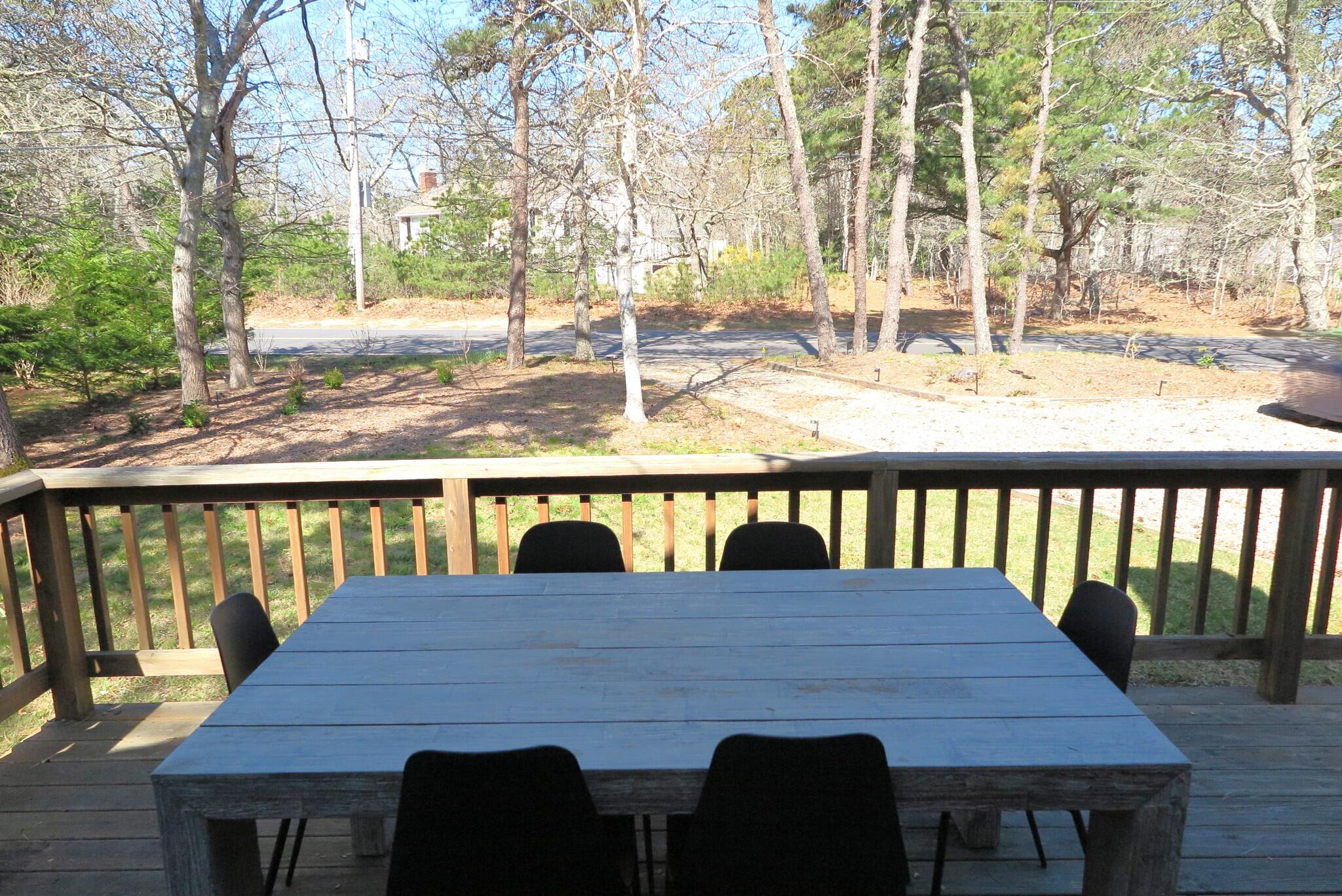 2420 Herring Brook Road Eastham, MA 02642 - Photo 27 of 37 a view of a balcony dining table and chairs with wooden floor