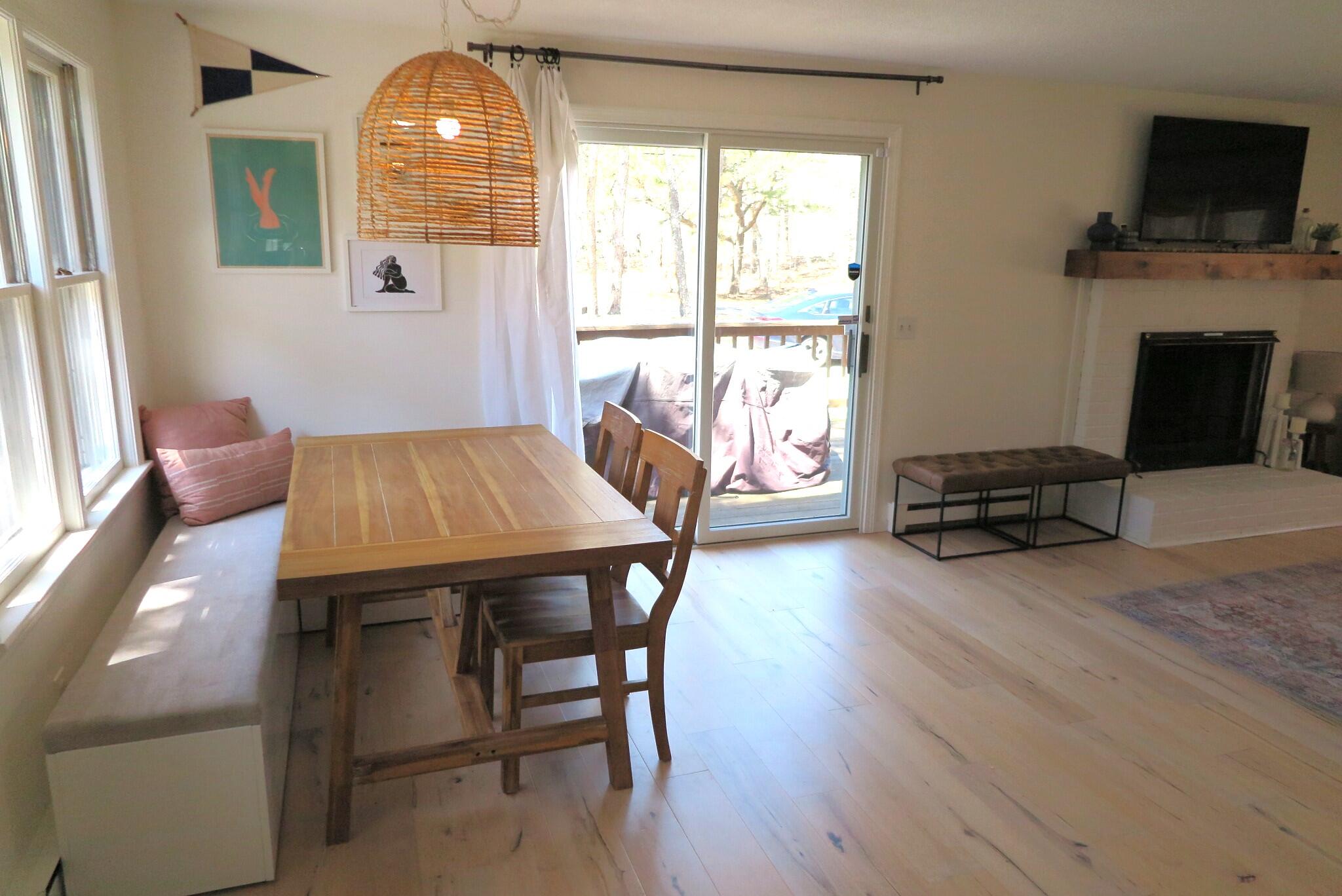 2420 Herring Brook Road Eastham, MA 02642 - Photo 7 of 37 a view of a dining room with furniture a fireplace and wooden floor