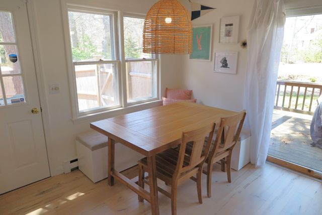 a view of a dining room with furniture a fireplace and wooden floor