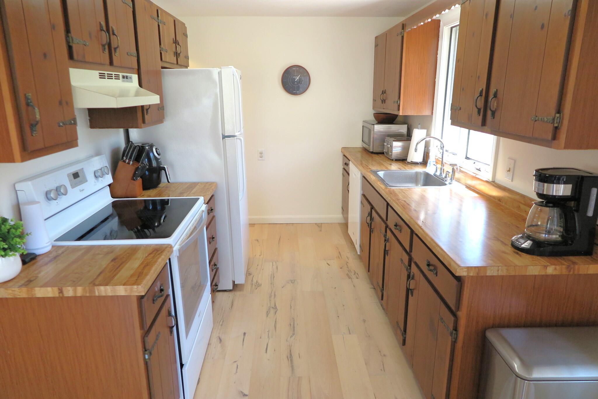 2420 Herring Brook Road Eastham, MA 02642 - Photo 9 of 37 a kitchen with sink a refrigerator and wooden cabinets