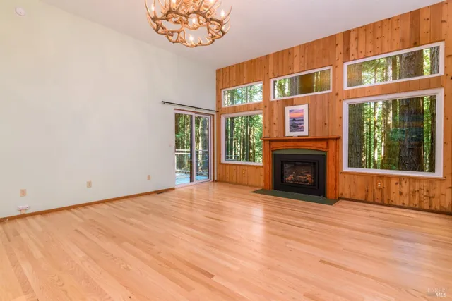 a view of an empty room with a fireplace and a window