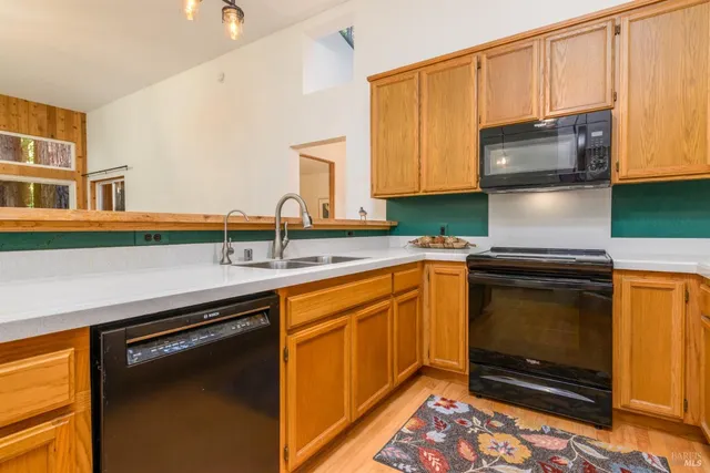 a kitchen with granite countertop a sink stove and microwave