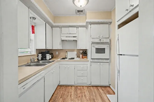 a kitchen with granite countertop white cabinets and white appliances