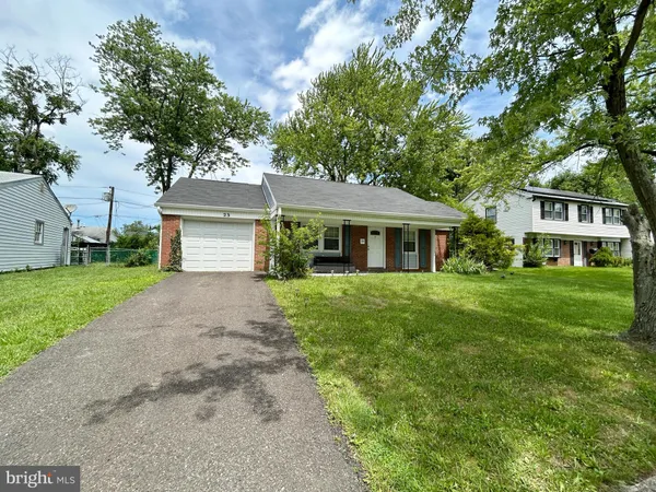 a front view of a house with a yard and trees