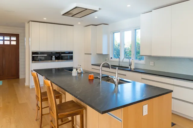 a kitchen with stainless steel appliances granite countertop a sink a stove and a counter space