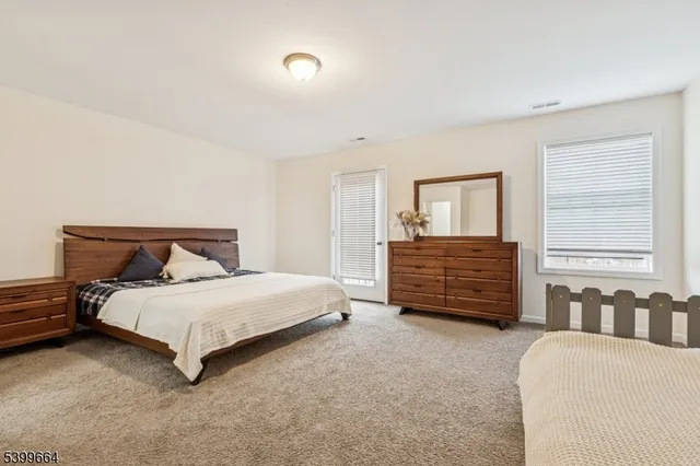 a bedroom with a bed a dresser and a window