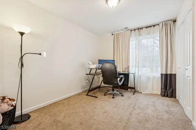 a view of a workspace with furniture and a window