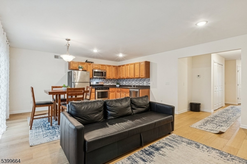 18 Joseph Drive, Unit 18 Newton, NJ 07860 - Photo 7 of 24 a living room with furniture and a dining table with kitchen view