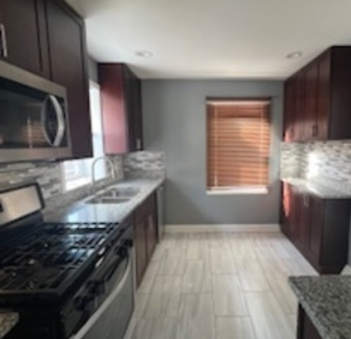 14918 Evers Street Dolton, IL 60419 - Photo 18 of 29 a kitchen with stainless steel appliances granite countertop a sink stove and microwave