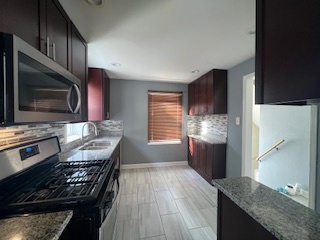 14918 Evers Street Dolton, IL 60419 - Photo 7 of 29 a kitchen with granite countertop stainless steel appliances and wooden cabinets