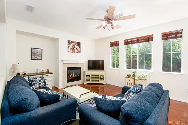 a living room with furniture a large window and a fireplace