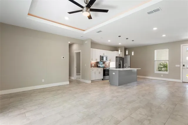 a kitchen with a sink a stove a microwave and white cabinets