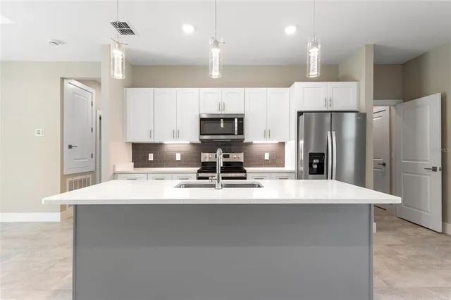 a kitchen with stainless steel appliances a refrigerator sink and microwave