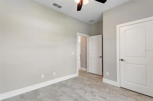 an empty room with a window and a fan