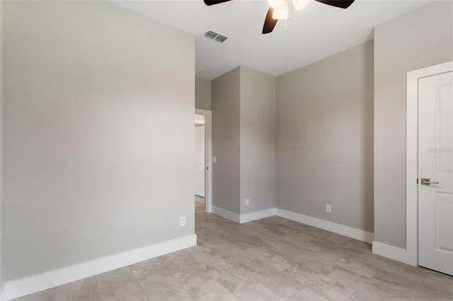 an empty room with a window and a fan