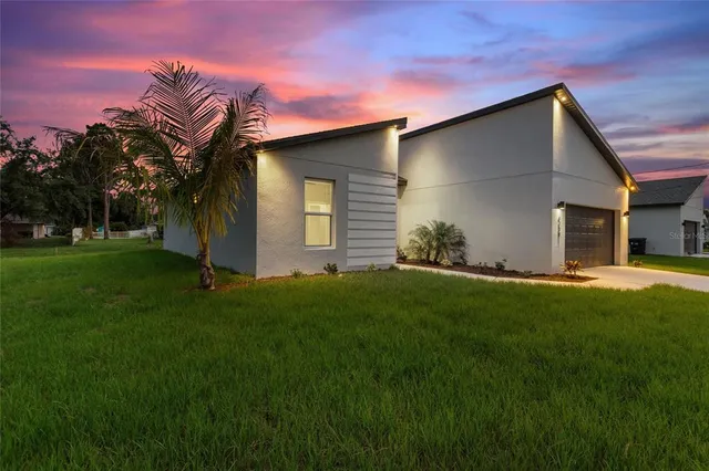 a backyard of a house with table and chairs