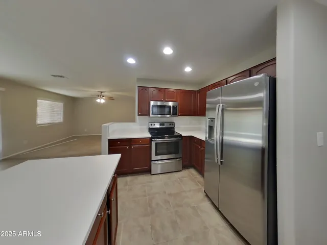 a kitchen with kitchen island a sink stainless steel appliances and cabinets