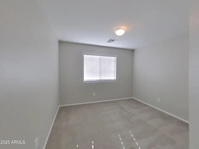 a view of an empty room with a chandelier fan