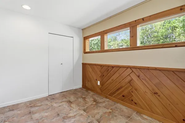 an empty room with a ceiling fan and carpet