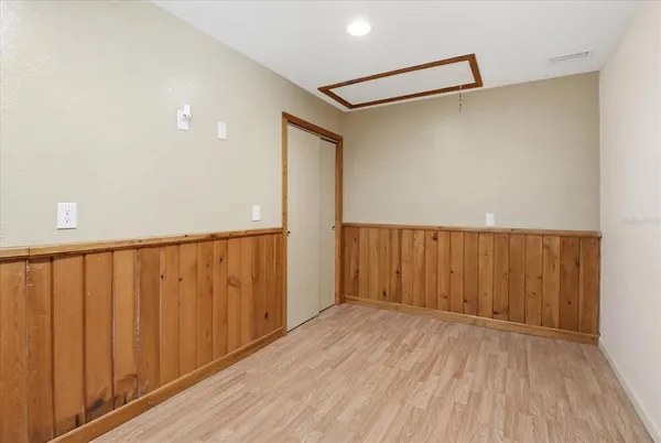 an empty room with a window and a fan