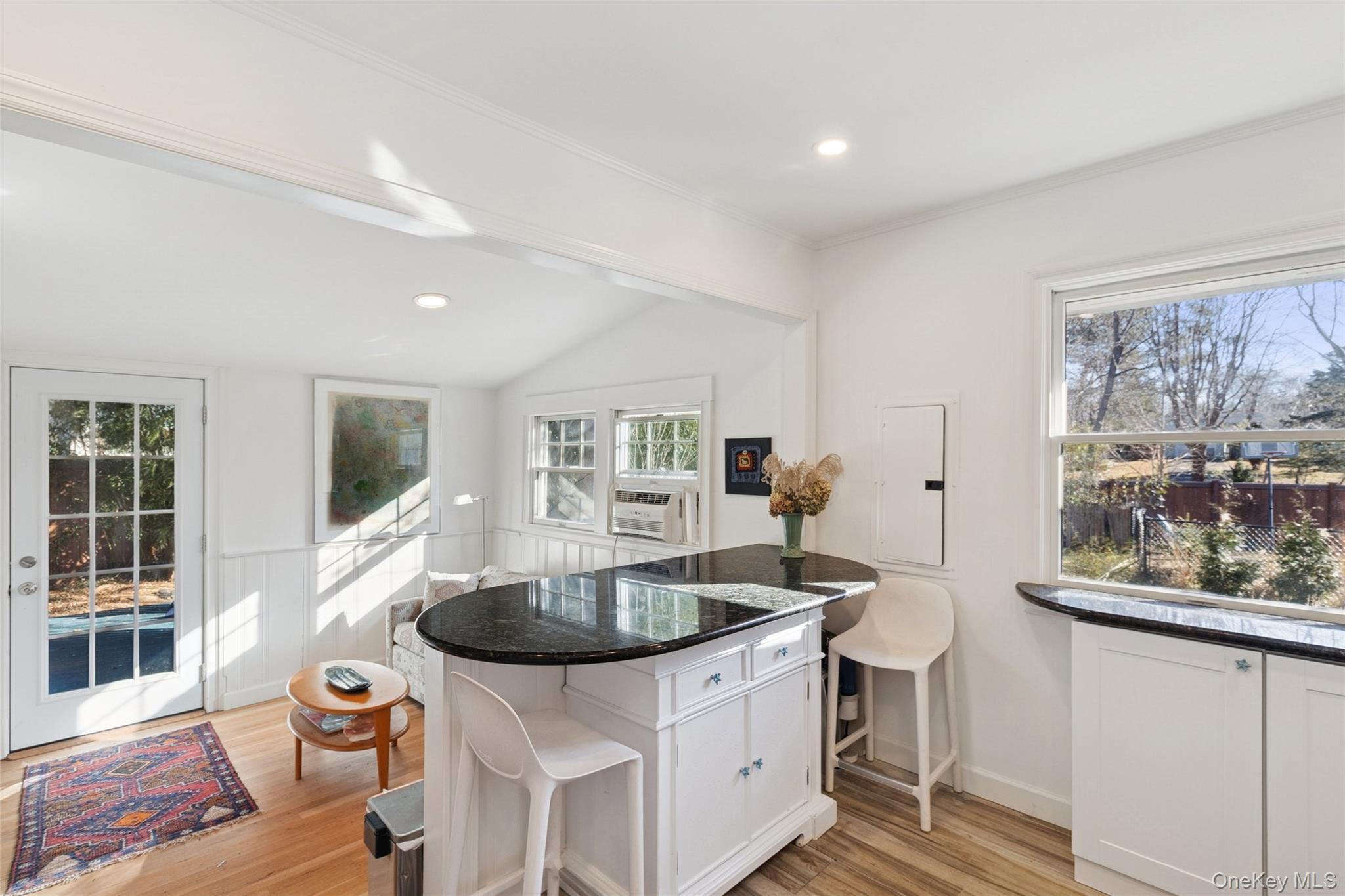 165 Springville Road, Unit A Hampton Bays, NY 11946 - Photo 12 of 22 Kitchen featuring white cabinets, a kitchen breakfast bar, dark stone countertops, a peninsula, and vaulted ceiling