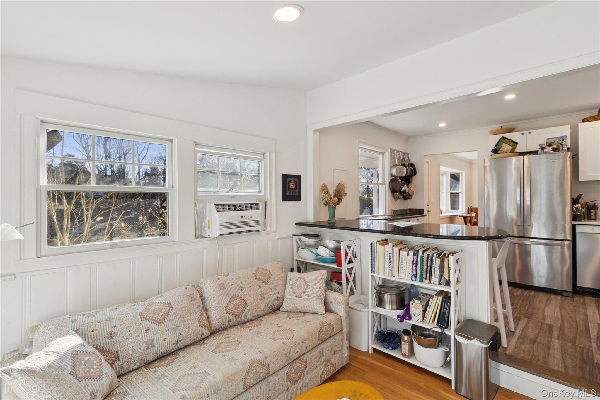 165 Springville Road, Unit A Hampton Bays, NY 11946 - Photo 13 of 22 Living room with light wood-style flooring, recessed lighting, a wainscoted wall, and a decorative wall