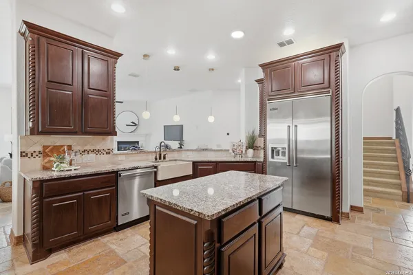 a kitchen with stainless steel appliances granite countertop a stove and a refrigerator