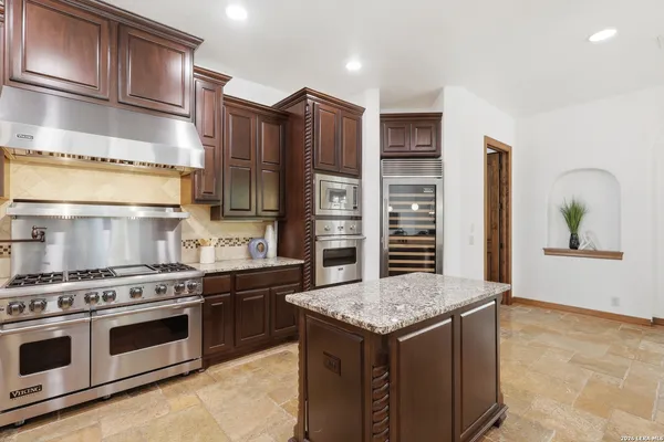 a large kitchen with kitchen island a sink stainless steel appliances and cabinets