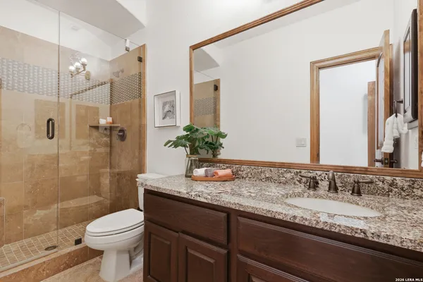 a view of an empty room with wooden floor and a bathroom