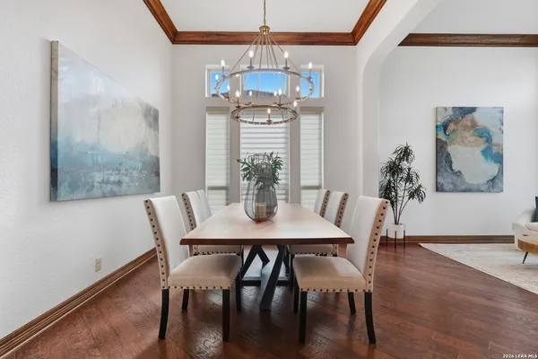 a dining room with furniture a chandelier and wooden floor
