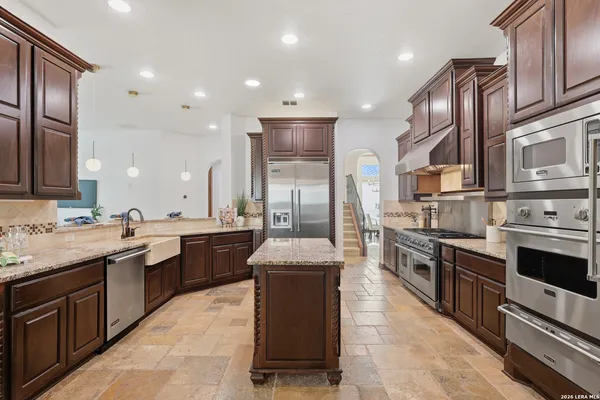 a kitchen with stainless steel appliances granite countertop a sink stove and refrigerator