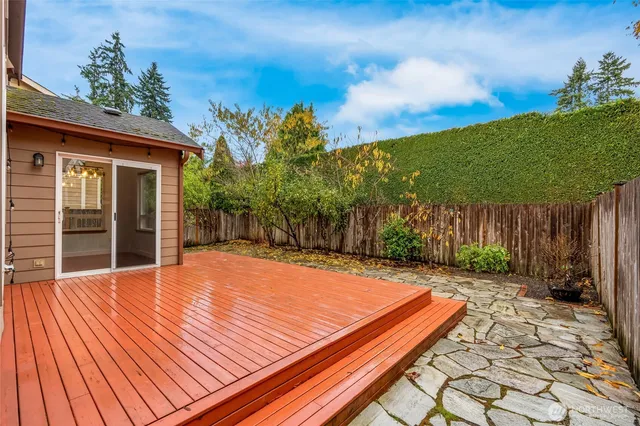 a view of a backyard with table and chairs with wooden floor and fence