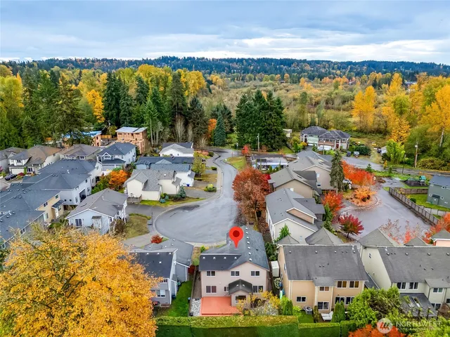 an aerial view of a city with lots of residential buildings ocean and mountain view in back