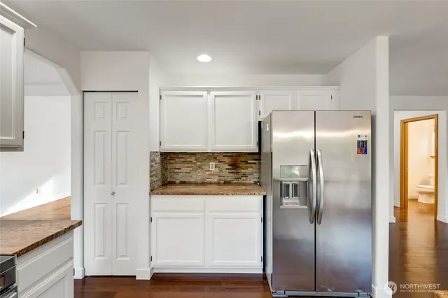 a kitchen with stainless steel appliances granite countertop a refrigerator and a stove