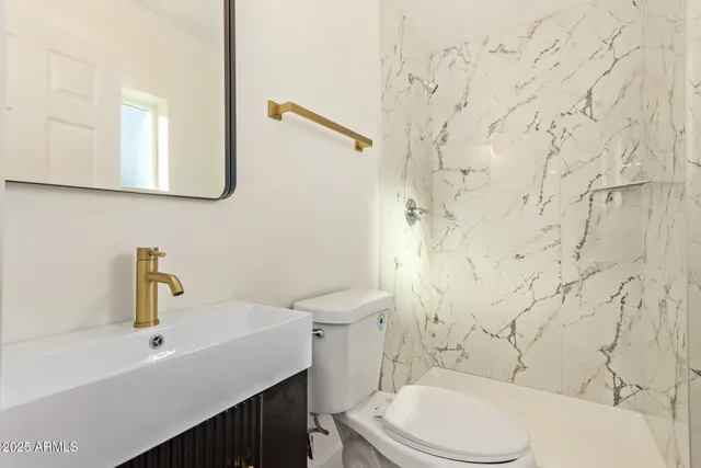 a bathroom with a sink a toilet and mirror