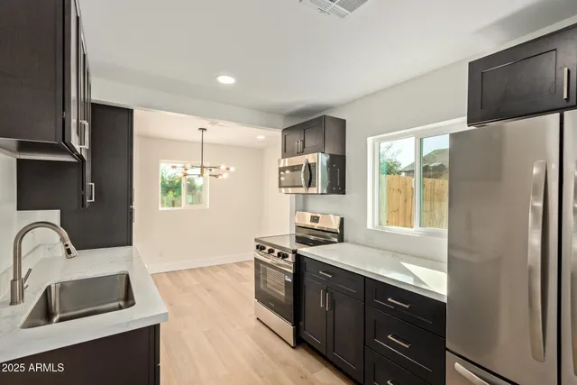 a kitchen with stainless steel appliances granite countertop a sink stove and refrigerator