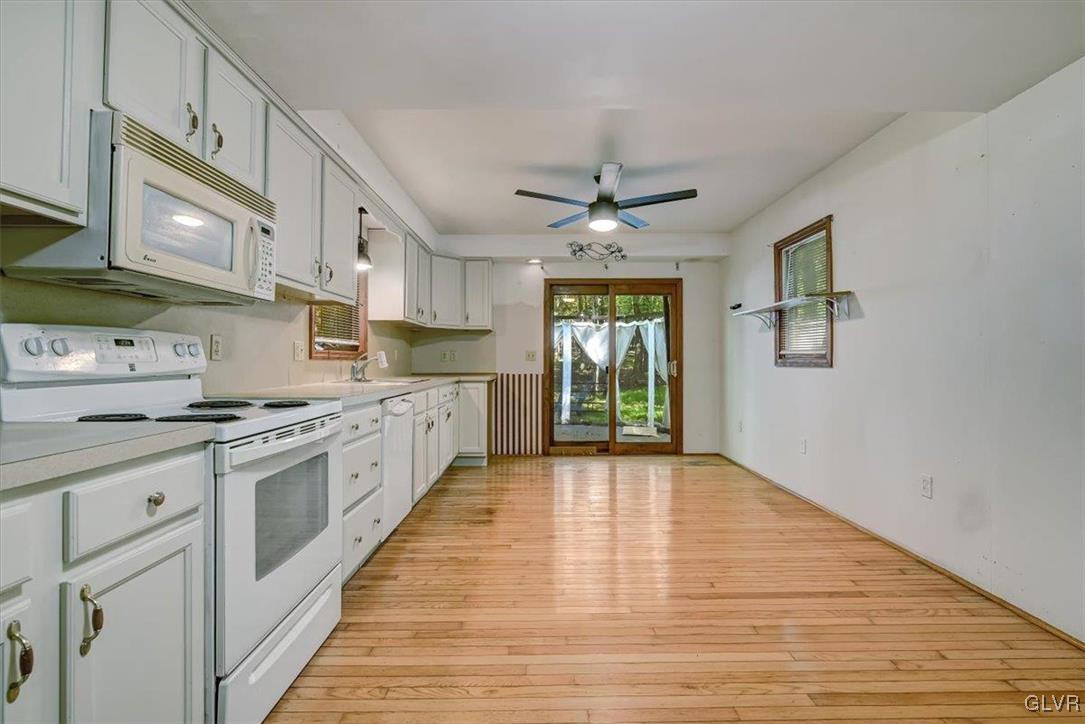 109 Sassafras Road Albrightsville, PA 18210 - Photo 14 of 49 a large kitchen with stainless steel appliances granite countertop a stove top oven a sink dishwasher and white cabinets with wooden floor
