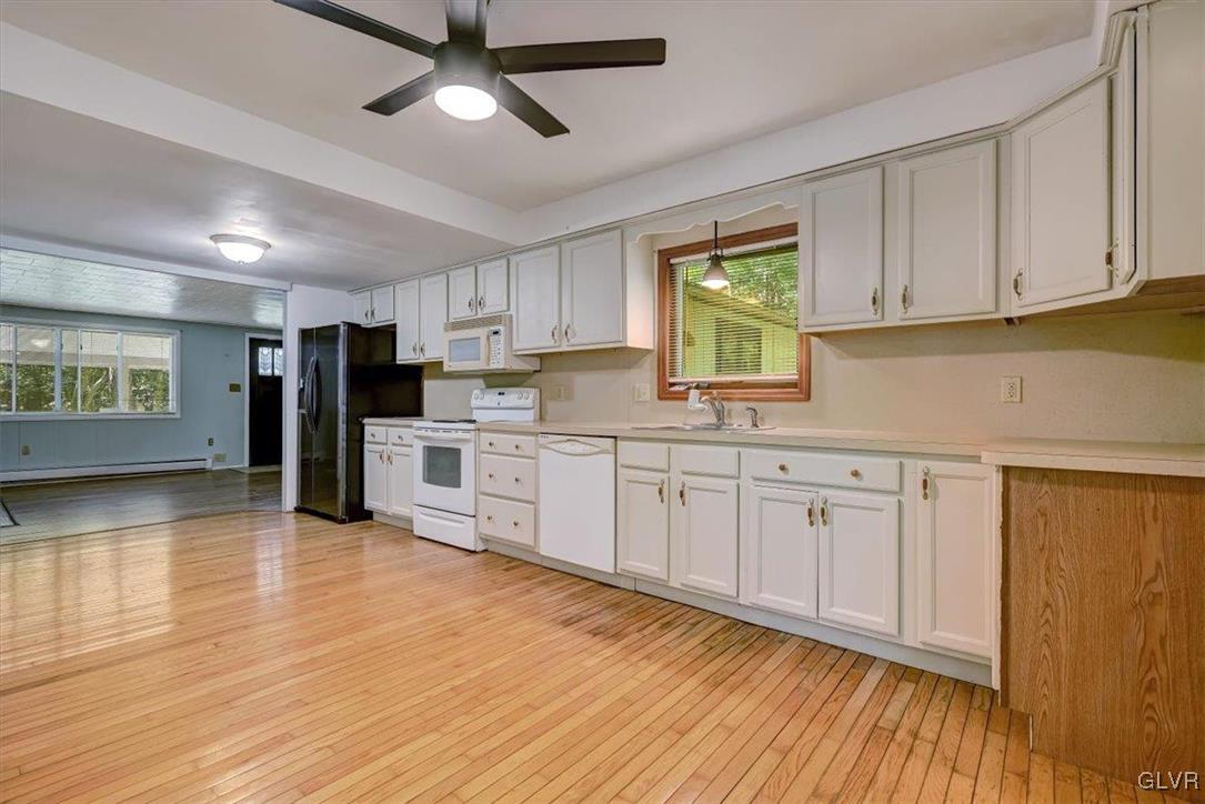 109 Sassafras Road Albrightsville, PA 18210 - Photo 16 of 49 a kitchen with stainless steel appliances granite countertop a refrigerator a sink dishwasher and white cabinets with wooden floor