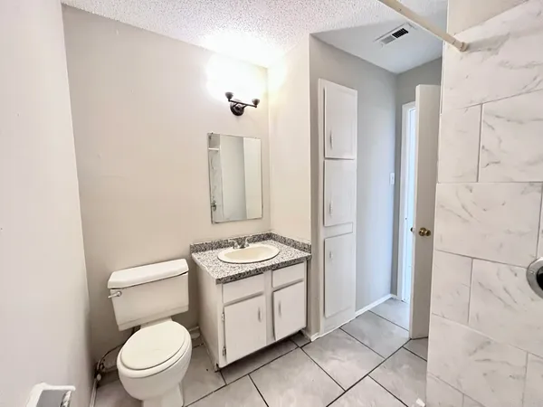 a bathroom with a toilet a sink and a mirror