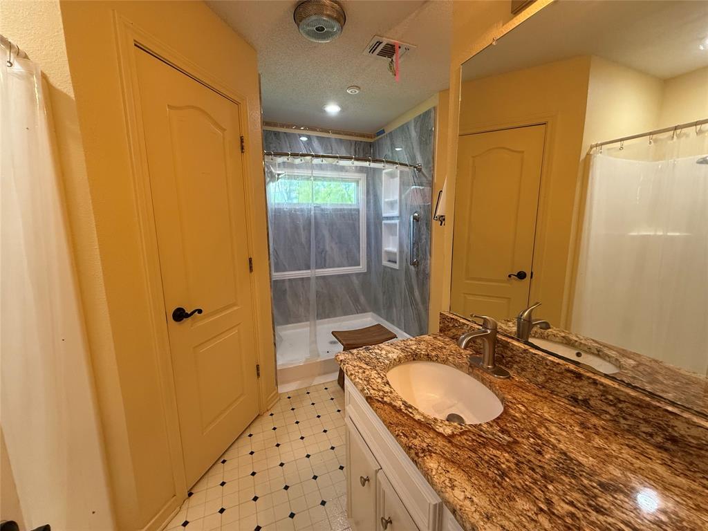 3016 County Road 4405 Commerce, TX 75428 - Photo 11 of 40 a bathroom with a sink and a mirror