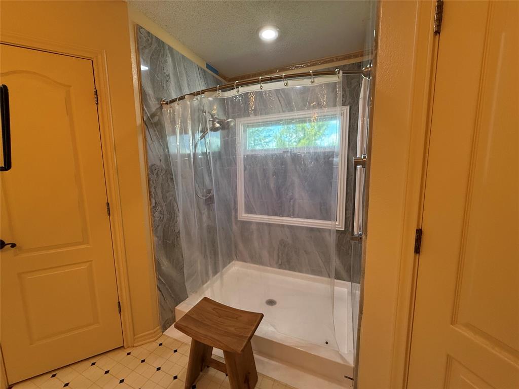 3016 County Road 4405 Commerce, TX 75428 - Photo 14 of 40 a bathroom with a bathtub and a shower