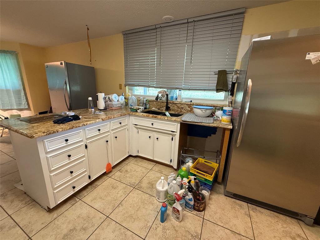 3016 County Road 4405 Commerce, TX 75428 - Photo 18 of 40 a kitchen with stainless steel appliances kitchen island granite countertop a sink stove and refrigerator
