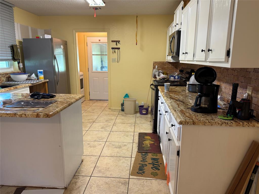 3016 County Road 4405 Commerce, TX 75428 - Photo 20 of 40 a kitchen with a sink a stove and cabinets