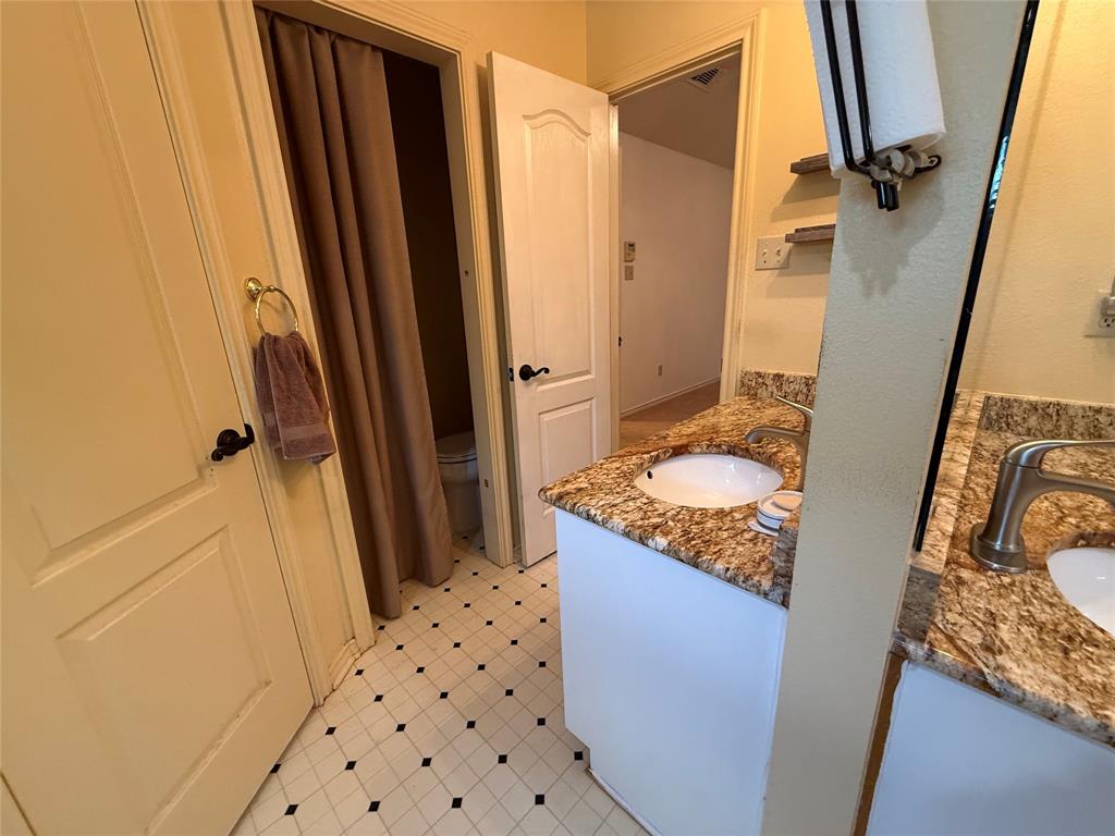 3016 County Road 4405 Commerce, TX 75428 - Photo 6 of 40 a bathroom with a granite countertop sink toilet and shower