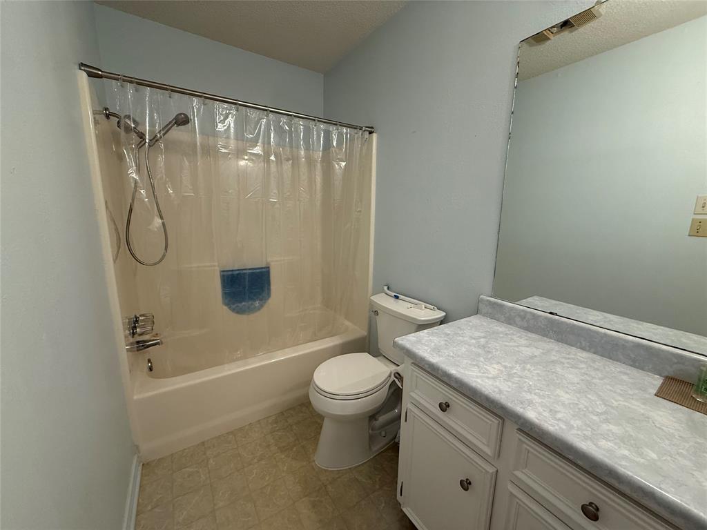 3016 County Road 4405 Commerce, TX 75428 - Photo 9 of 40 a bathroom with a granite countertop sink toilet and shower